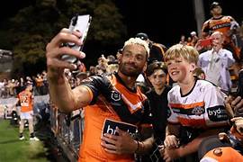 Wests Tigers co-captain Api Koroisau taking selfies with young fan, after win over Raiders at Leichhardt oval