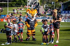 Group of kids with Wests Tigers players and Tigers mascots